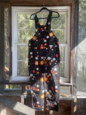 Run & Fly overalls, black with lighthearted magical and alchemy symbols